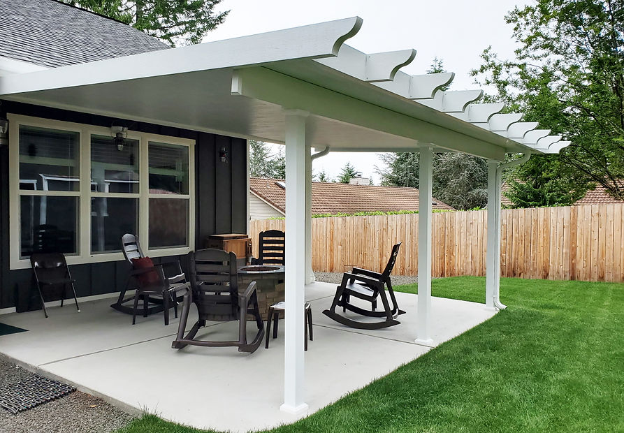 White insulated-pan patio cover with scalloped rafter tails on a residential patio.